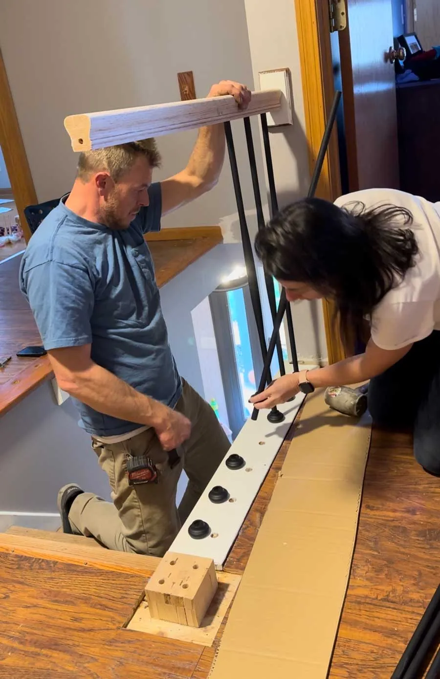 installing iron balusters into staircase